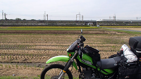 広い田んぼの横を通過する新幹線